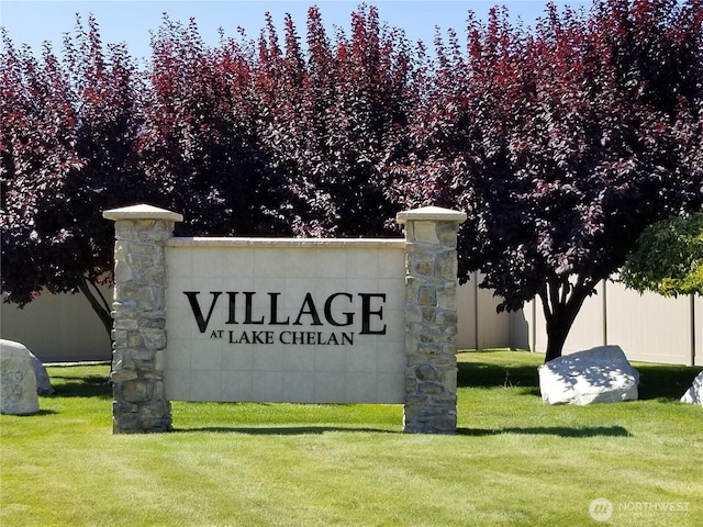 community sign featuring a lawn and fence