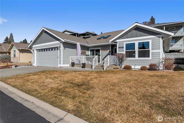 ranch-style house featuring an attached garage, driveway, board and batten siding, and a front yard