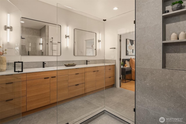 full bathroom featuring a sink, double vanity, a shower stall, and recessed lighting