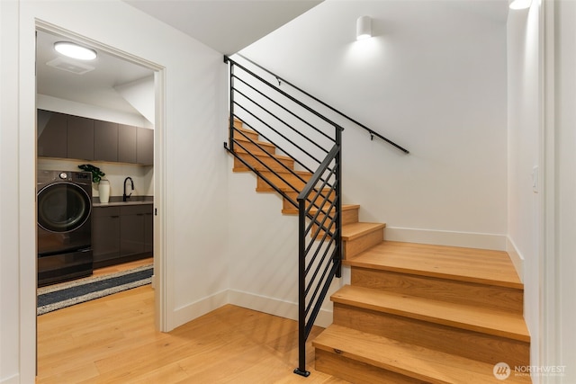 stairs featuring baseboards, visible vents, washer / clothes dryer, and wood finished floors