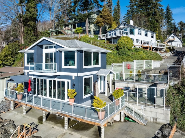 back of property featuring roof with shingles and a balcony