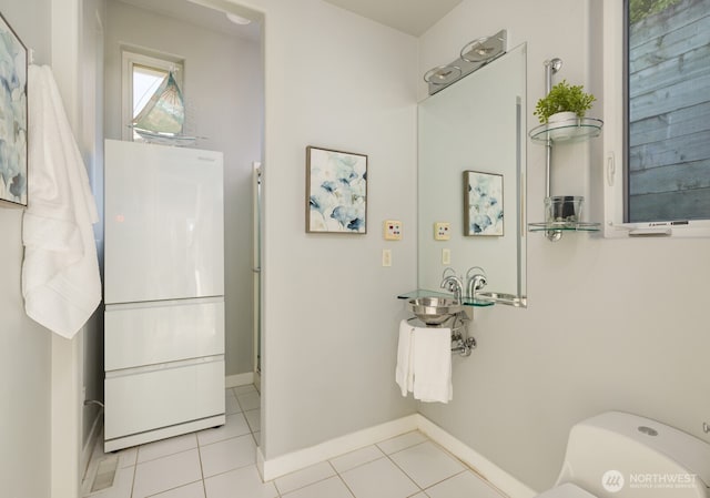 bathroom with toilet, tile patterned flooring, and baseboards