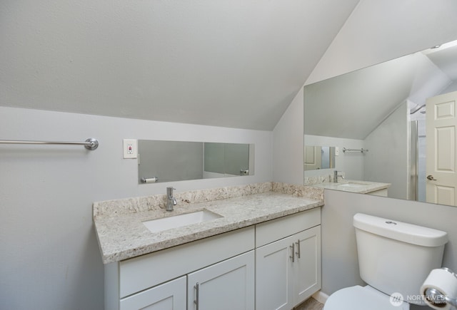 full bathroom featuring toilet, vaulted ceiling, and vanity