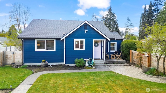 bungalow-style home featuring fence, a shingled roof, and a front yard