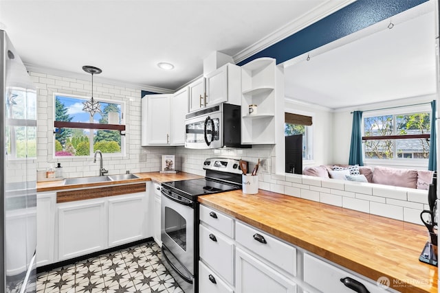 kitchen with crown molding, appliances with stainless steel finishes, a sink, and wooden counters