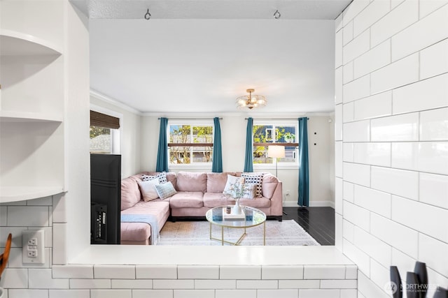 living area with a notable chandelier, baseboards, and crown molding