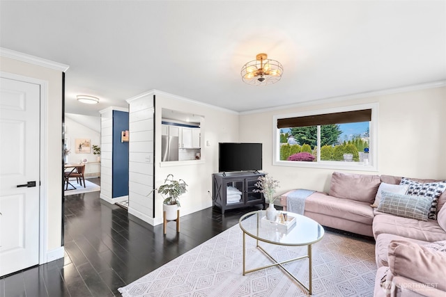 living area featuring baseboards, crown molding, wood finished floors, and an inviting chandelier