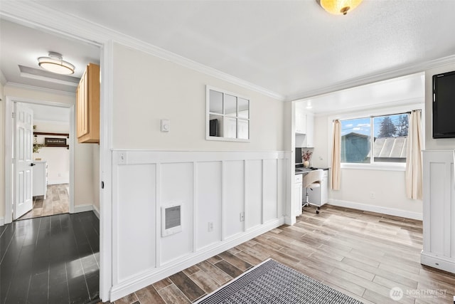 interior space with light wood finished floors, visible vents, and ornamental molding