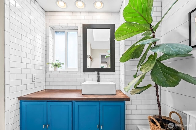 bathroom featuring backsplash, vanity, and tile walls