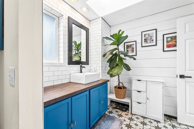 bathroom featuring tile patterned floors, vanity, and backsplash