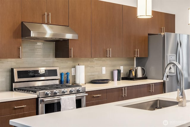 kitchen featuring stainless steel appliances, backsplash, light countertops, and under cabinet range hood