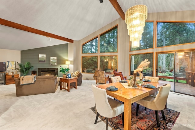 carpeted dining room with a warm lit fireplace, high vaulted ceiling, beam ceiling, and an inviting chandelier