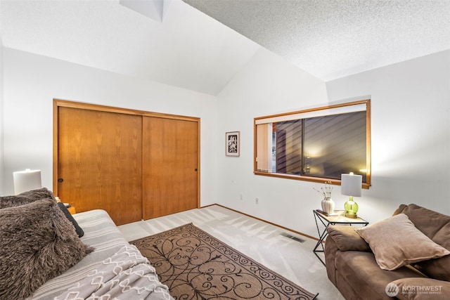 living area featuring lofted ceiling, visible vents, carpet flooring, a textured ceiling, and baseboards