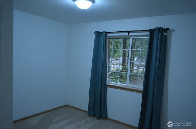 empty room featuring carpet floors and baseboards