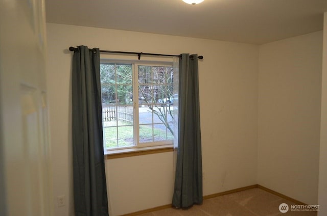 carpeted empty room with baseboards