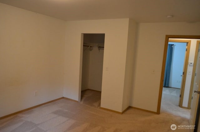 unfurnished bedroom featuring a closet, light colored carpet, and baseboards