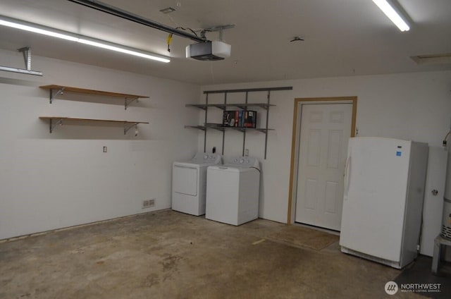 garage with a garage door opener, freestanding refrigerator, and washing machine and clothes dryer