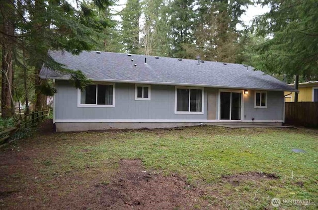 back of house with a yard, roof with shingles, a patio area, and fence