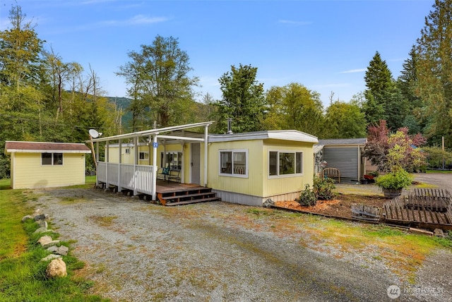 view of front of house with a storage shed, a deck, and an outdoor structure