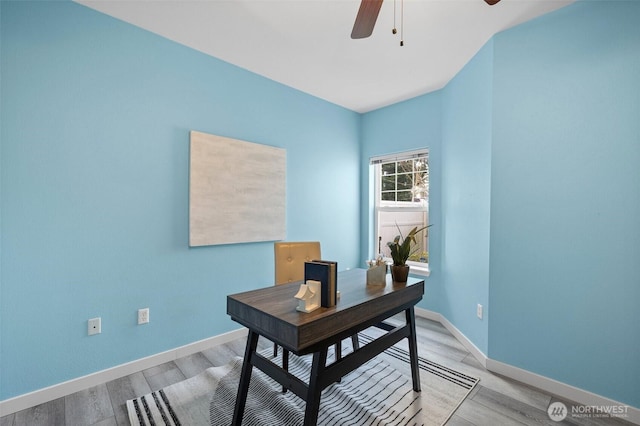 office space with a ceiling fan, light wood-style flooring, and baseboards