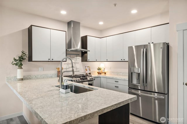 kitchen featuring wall chimney exhaust hood, a sink, light countertops, and stainless steel fridge with ice dispenser