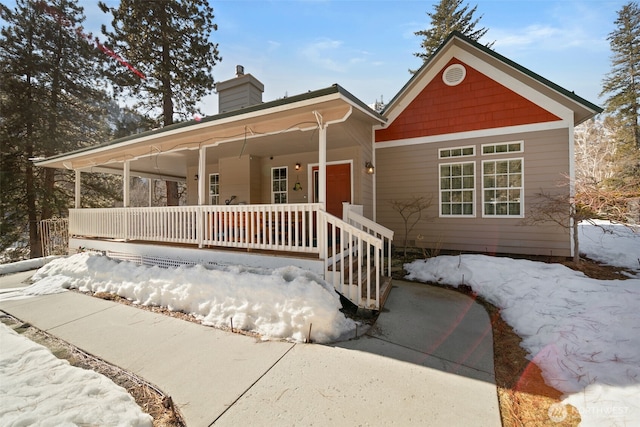 view of front of property with a porch and a chimney