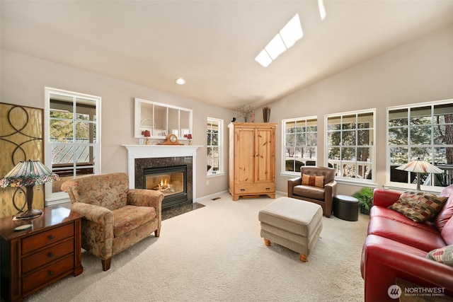 living room featuring carpet floors, a healthy amount of sunlight, a fireplace, and vaulted ceiling