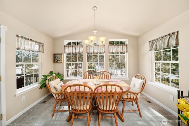 dining area with lofted ceiling, baseboards, a wealth of natural light, and a notable chandelier