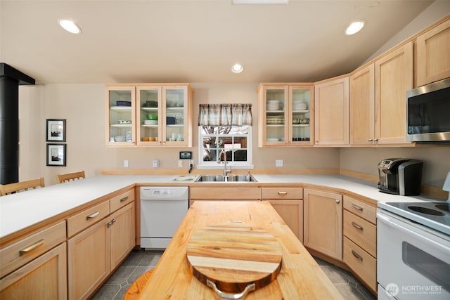 kitchen featuring white appliances, tile patterned floors, light brown cabinets, wooden counters, and a sink