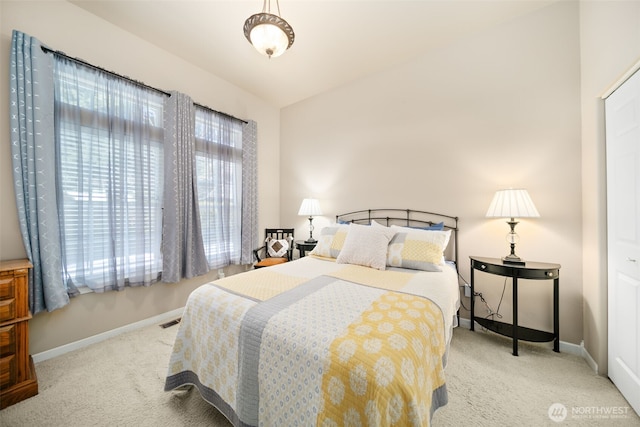 bedroom with vaulted ceiling, carpet flooring, visible vents, and baseboards