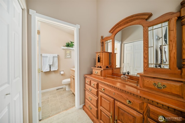 bathroom with toilet, baseboards, and vanity