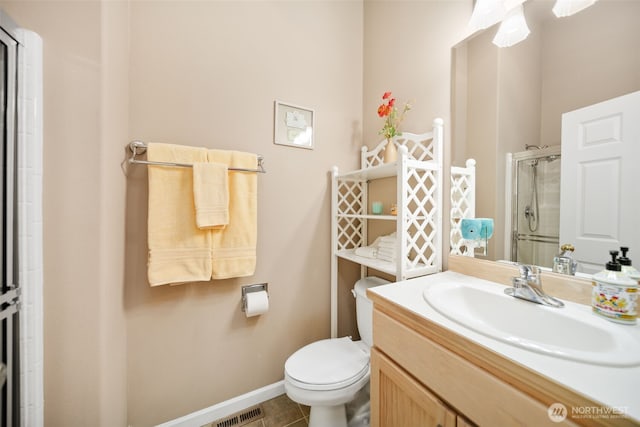 bathroom with toilet, visible vents, vanity, baseboards, and a stall shower