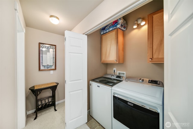 laundry room featuring washing machine and dryer, cabinet space, and baseboards