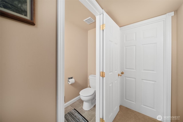 bathroom featuring toilet, baseboards, visible vents, and tile patterned floors