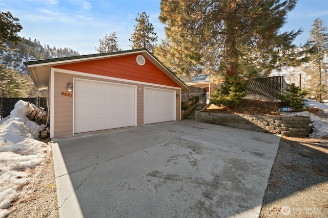 detached garage featuring fence