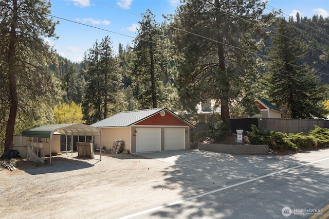 single story home with an outdoor structure, fence, metal roof, and a garage