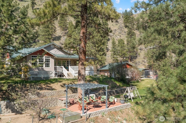 view of front of home with a pergola and a forest view