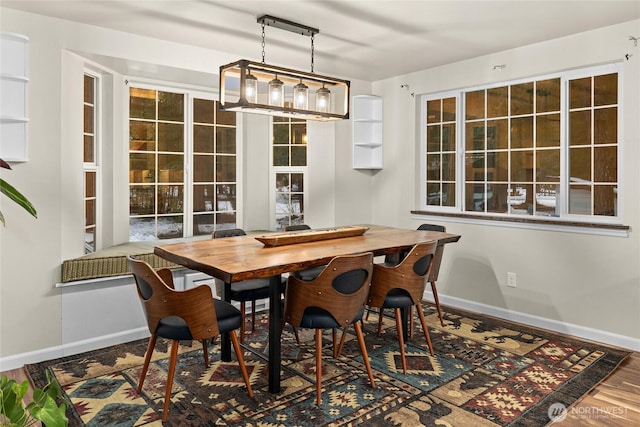 dining area with baseboards and wood finished floors