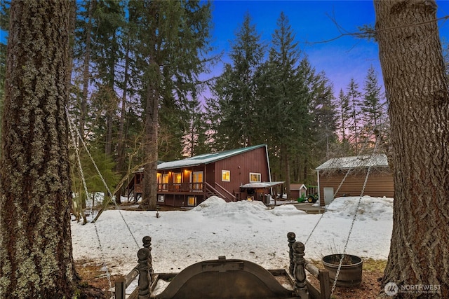 snow covered house featuring a wooden deck