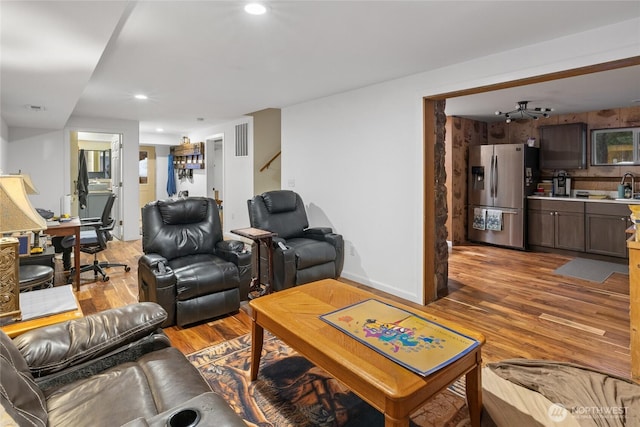 living room with light wood-style floors, baseboards, and recessed lighting