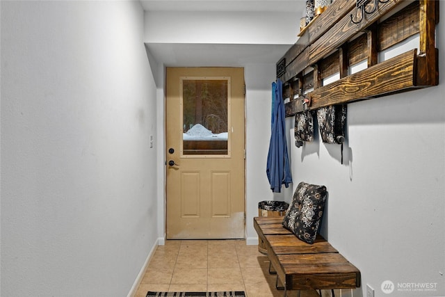 doorway with baseboards and light tile patterned floors