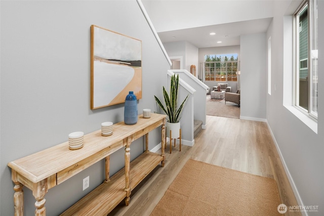 hall featuring stairs, baseboards, wood finished floors, and recessed lighting