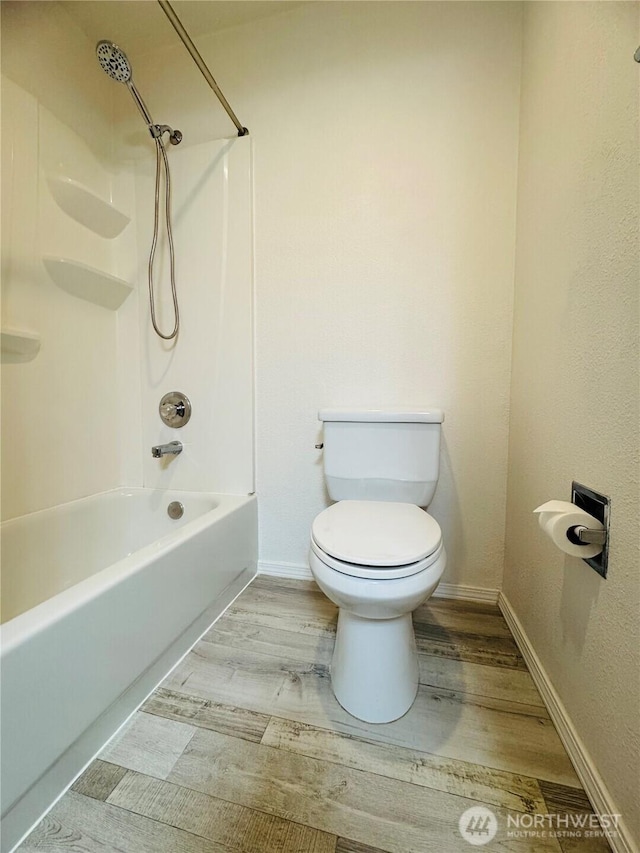 full bathroom featuring tub / shower combination, wood finished floors, toilet, and baseboards