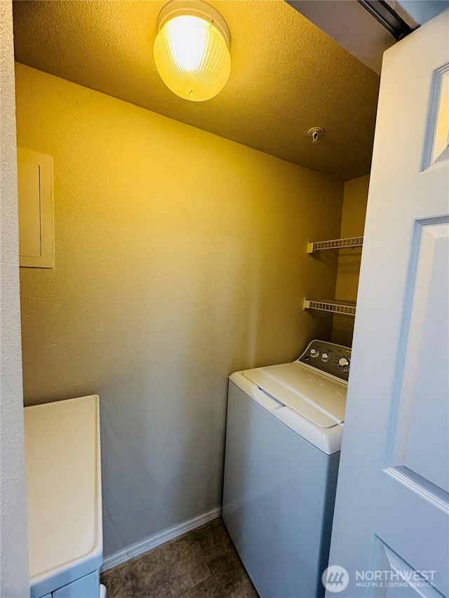 laundry room with washer / dryer, a textured ceiling, and baseboards