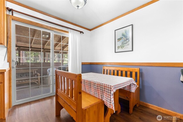 dining area with wood finished floors, baseboards, and ornamental molding