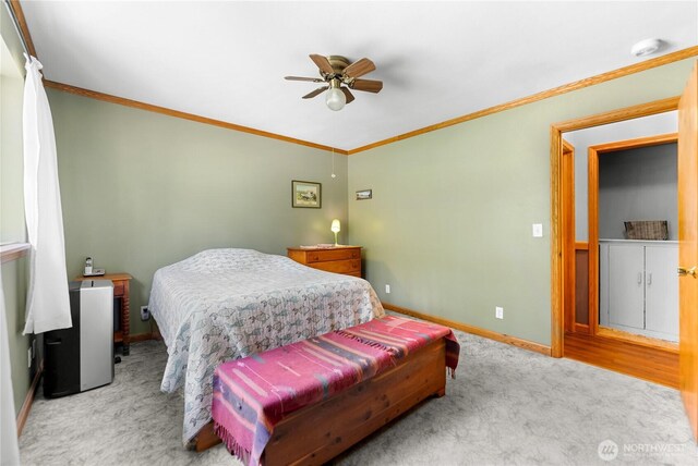 bedroom with ceiling fan, baseboards, carpet floors, and ornamental molding