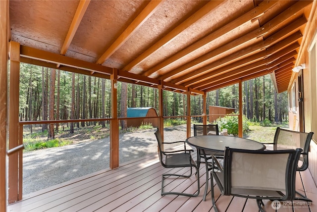 sunroom / solarium with a wooded view