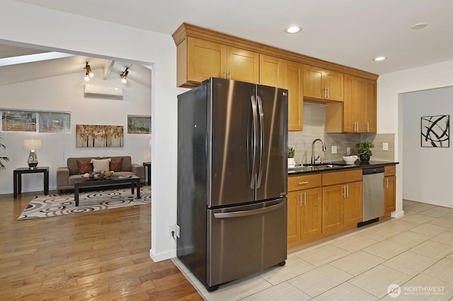 kitchen featuring stainless steel appliances, dark countertops, backsplash, an AC wall unit, and a sink