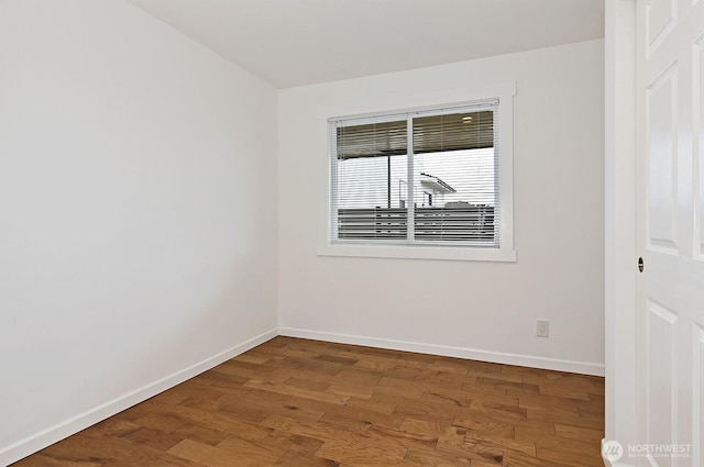 unfurnished room with baseboards and wood finished floors