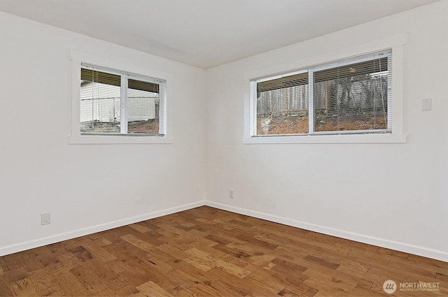 spare room featuring wood finished floors and baseboards